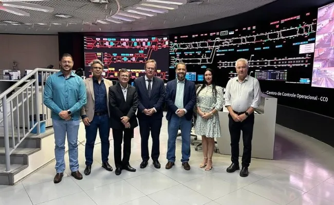 Grupo posa no Centro de Controle Operacional do Metrô-DF, diante de painéis de monitoramento