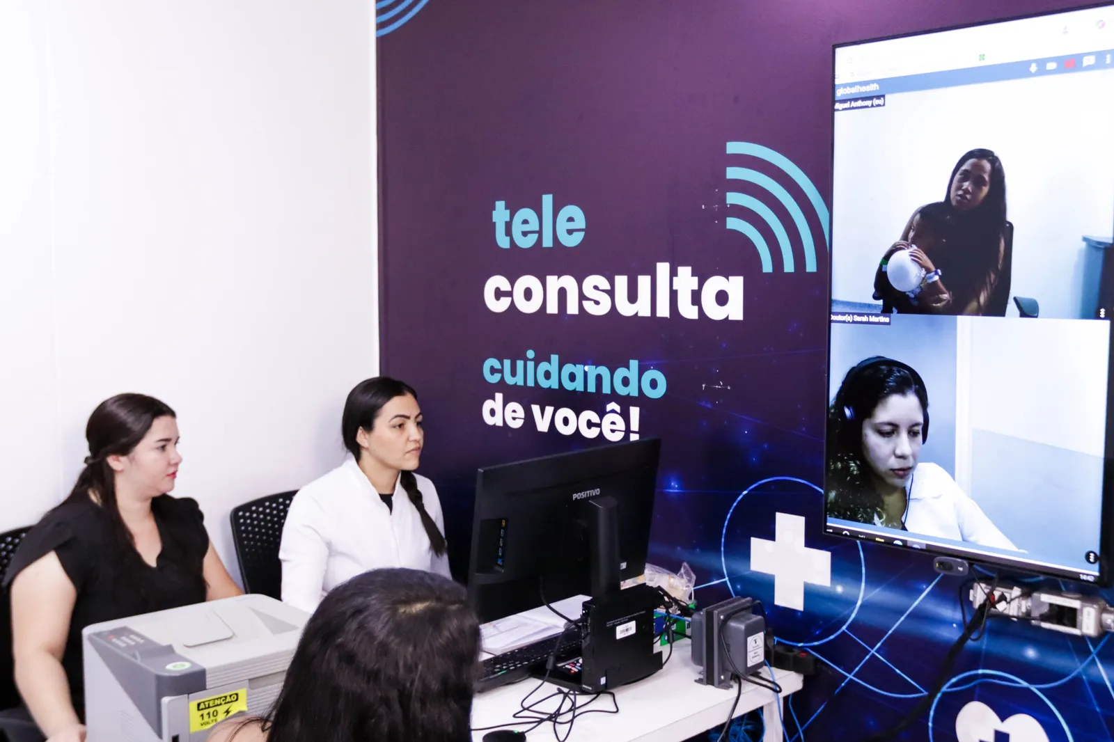 Equipe de saúde diante da tela de teleconsulta em sala de UPA