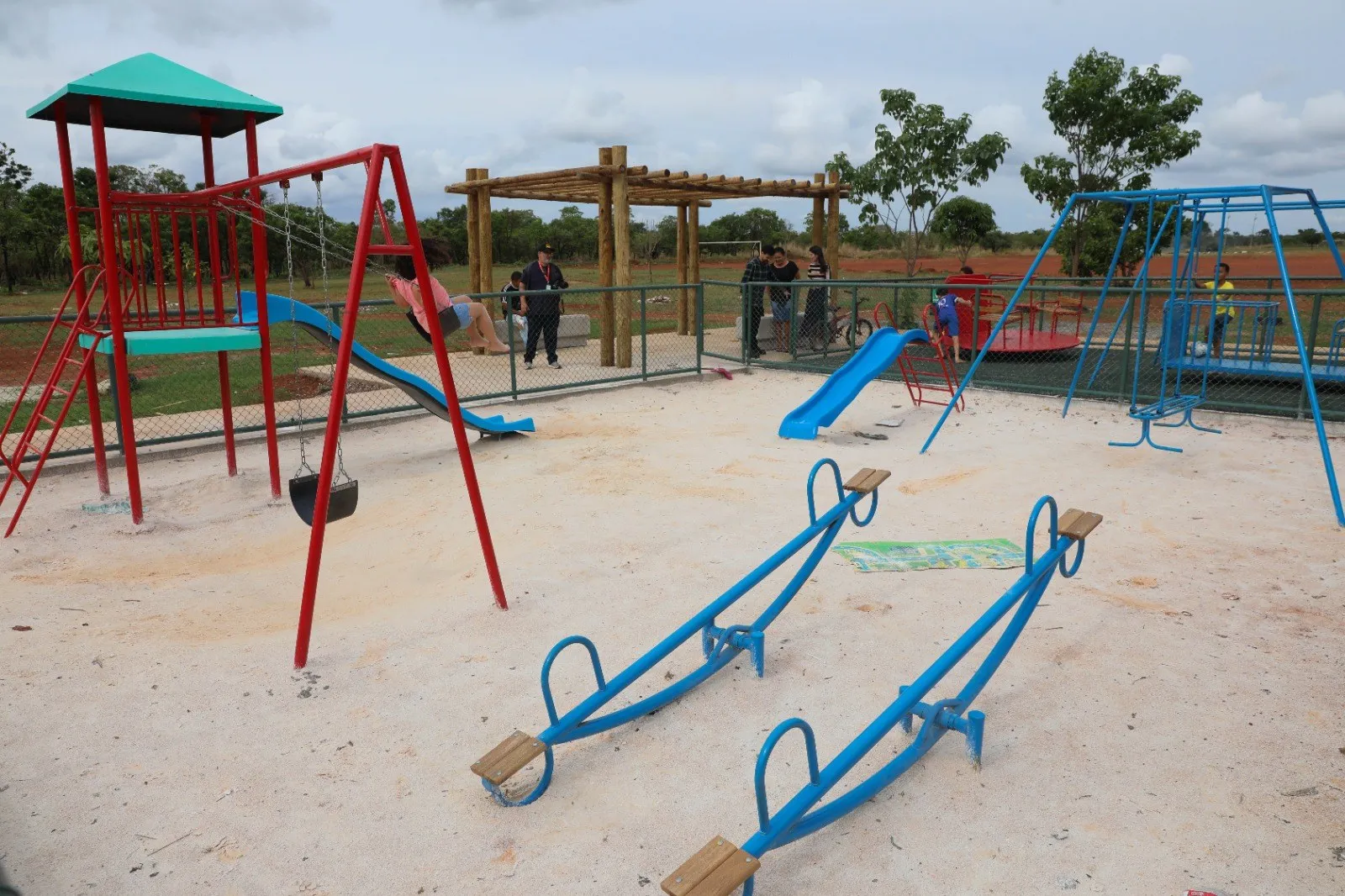 Parquinho novo da Quadra 1 do Jardim Roriz, com balanços, gangorras e escorregador sobre areia
